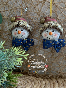 Set of 2 Snowman Head Ornaments – Rustic Resin with Blue Bow & Santa Hat